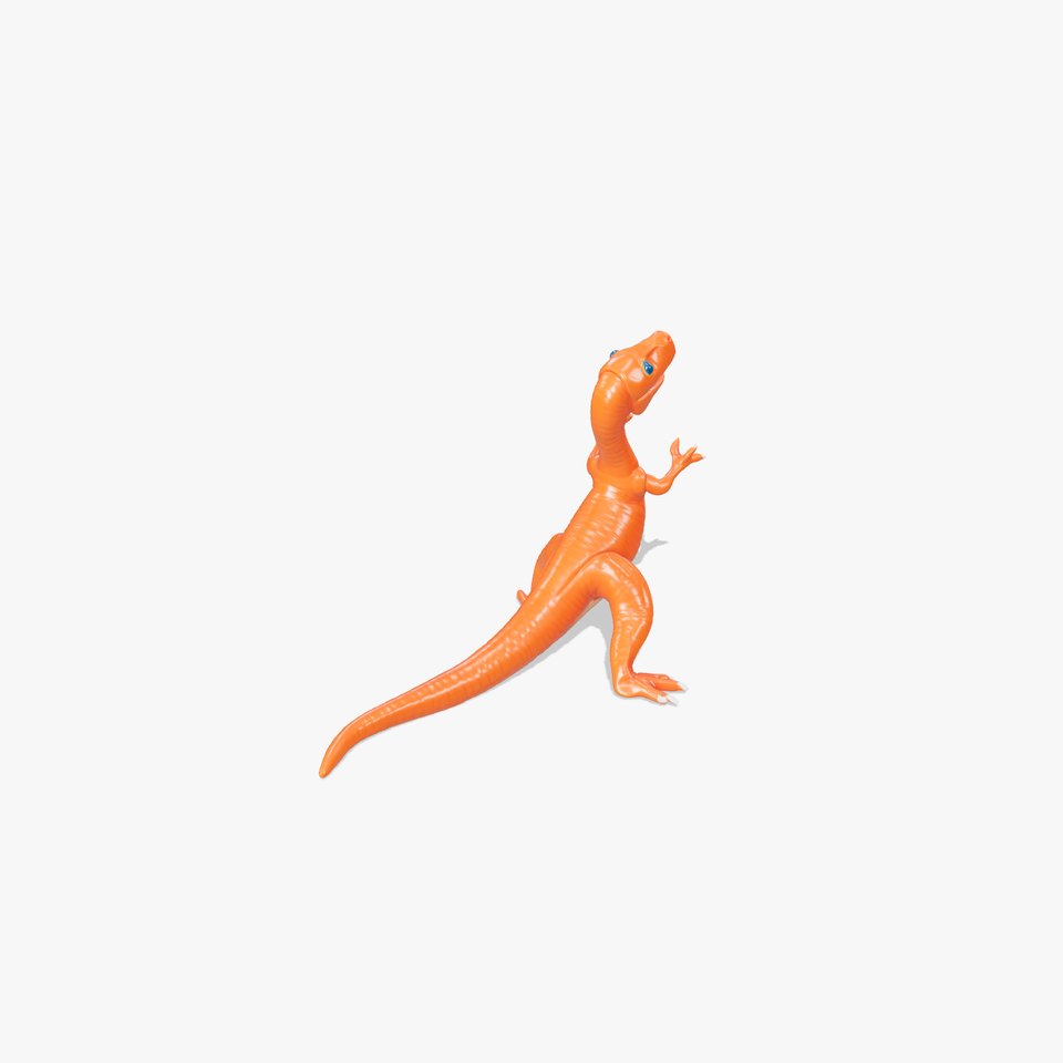 A burnt orange plastic dinosaur bubbly eyes and scrambling feet embodying a joyous stance